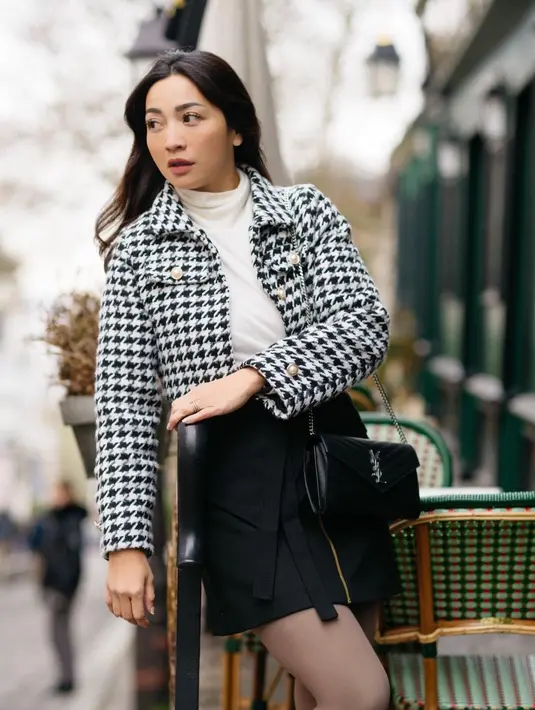 Hesti Purwadinata juga tak melewatkan momen liburan akhir tahun. Ia pergi bersama beberapa rekan seleb berkeliling Eropa. Di foto ini, Hesti tampil chic saat berada di Paris, ia mengenakan turtleneck sweater berwarna putih sebagai innerwear, yang ditumpuknya dengan cropped blazer kotak-kotak hitam-putih, dipadu dengan mini skirt hitam dengan detail zip di bagian tengah. Ia juga tampak mengenakan stoking hitam. Foto: Instagram.