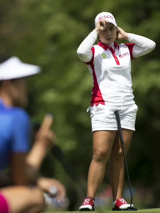 Moriya Jutanugarn, dari Thailand, menyaksikan Michelle Wie menempatkan puttnya di lubang ke-17 pada hari terakhir Meijer LPGA Classic di Blythefield Country Club di Grand Rapids, Mich, (18/6). (Mike Clark / Grand Rapids Press via AP)