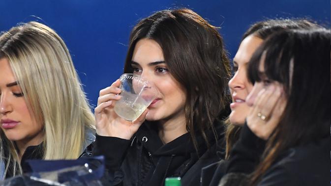 Model Kendall Jenner menikmati minuman saat menyaksikan Los Angeles Rams dan Baltimore Ravens di Los Angeles Memorial Coliseum di Los Angeles, California (25/11/2019). Kendall Jenner datang bersama teman-temannya menyaksikan American Football tersebut. (Jayne Kamin-Oncea/Getty Images/AFP)