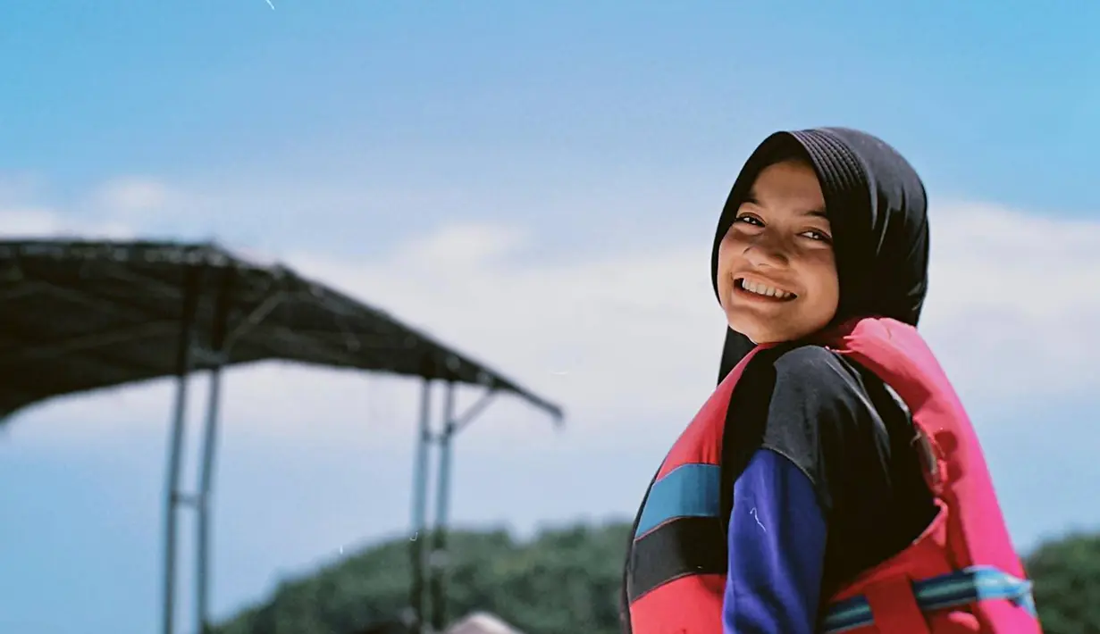 Tampil tertup sambil mengenakan hijab dan pelampung, menjadi salah satu outfitnya saat menikmati olahraga air. Dalam berbagai kesempatan, Ratu Sofya memang banyak membagikan momen serunya saat liburan di pantai belakangan ini. (Liputan6.com/IG/@ratusfy_)