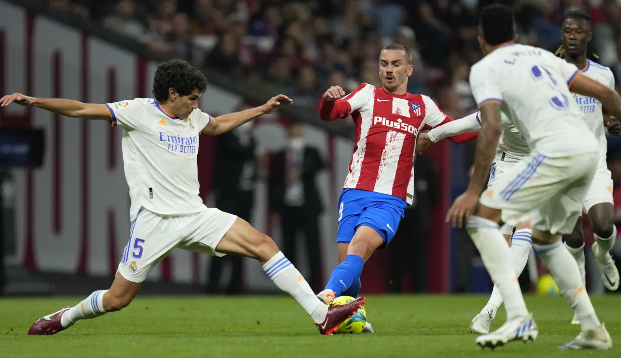 <p>Bek Real Madrid Jesus Vallejo berbeut bola dengan penyerang&nbsp;Atletico Madrid Antoine Griezmann&nbsp;dalam laga pekan ke-35 Liga Spanyol di Wanda Metropolitano, Senin (9/5/2022) dini hari WIB. Atletico Madrid berhasil menang dengan skor tipis 1-0 atas Real Madrid. (AP Photo/Manu Fernandez)</p>