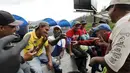 Sejumlah imigran asal Kuba berkumpul dan berbincang bersama saat waktu istirahat di tempat pencucian mobil, Quito, Ekuador , (1/12). Pemerintah Ekuador mengumumkan bahwa warga Kuba yang berada di Ekuador wajib mempunyai Visa. (REUTERS/Guillermo Granja)