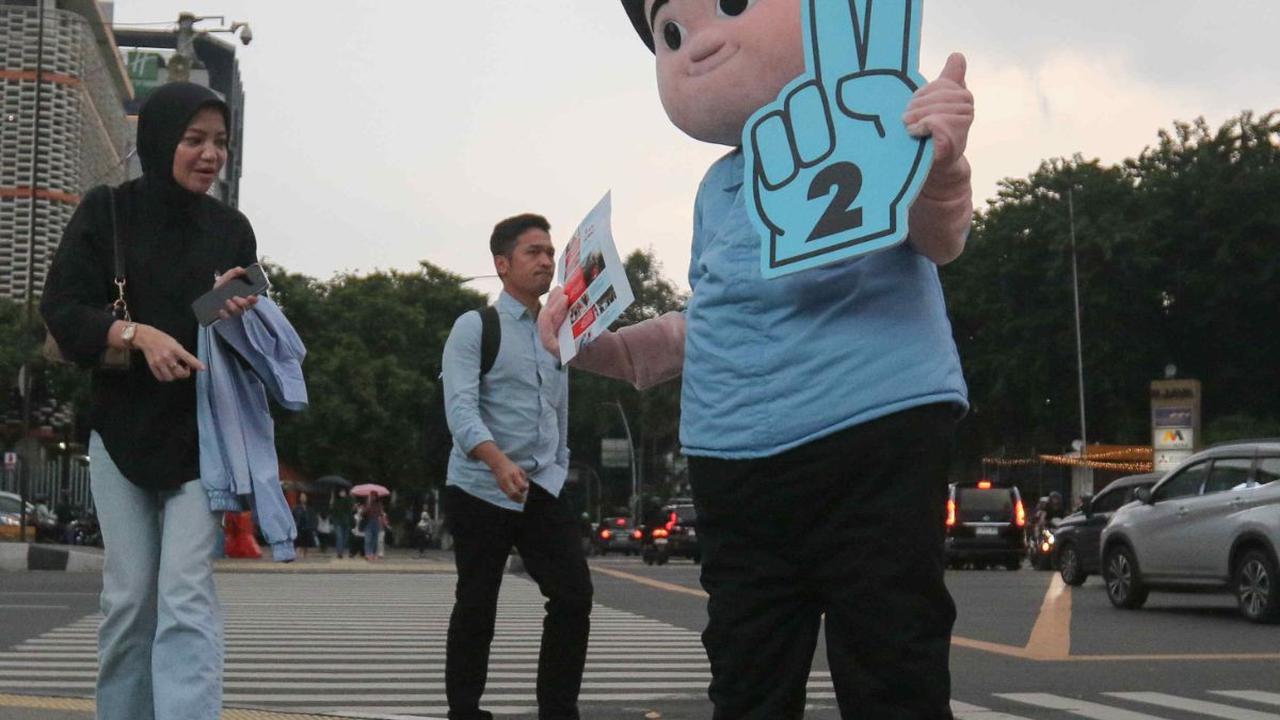 Relawan berkostum boneka Prabowo Subianto melakukan kampanye di perempatan kawasan Sarinah, Jalan Jenderal MH Thamrin, Jakarta, Jumat (29/12/2023). Dalam kampanyenya, relawan Prabowo dan Gibran ini tampak menyapa warga sembari membagikan susu gratis.