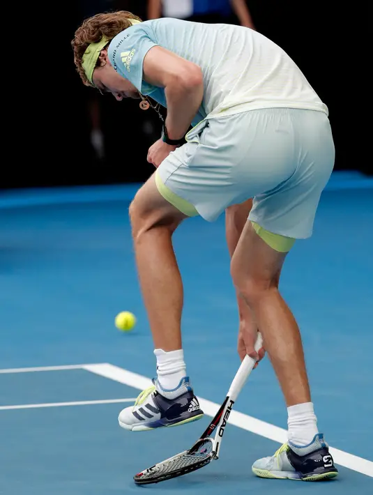 Petenis Jerman, Alexander Zverev menginjak raketnya seusai menghadapi petenis Korea Selatan, Chung Hyeon di turnamen Australia Terbuka, 20 Januari 2018.  Raket tersebut bengkok dan tidak dapat digunakan lagi. (AP/Vincent Thian)