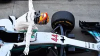 Pebalap Mercedes, Lewis Hamilton, melakukan selebrasi setelah memenangi balapan F1 GP Jepang di Sirkuit Suzuka, Minggu (8/10/2017). (Bola.com/Twitter/suttonimages)