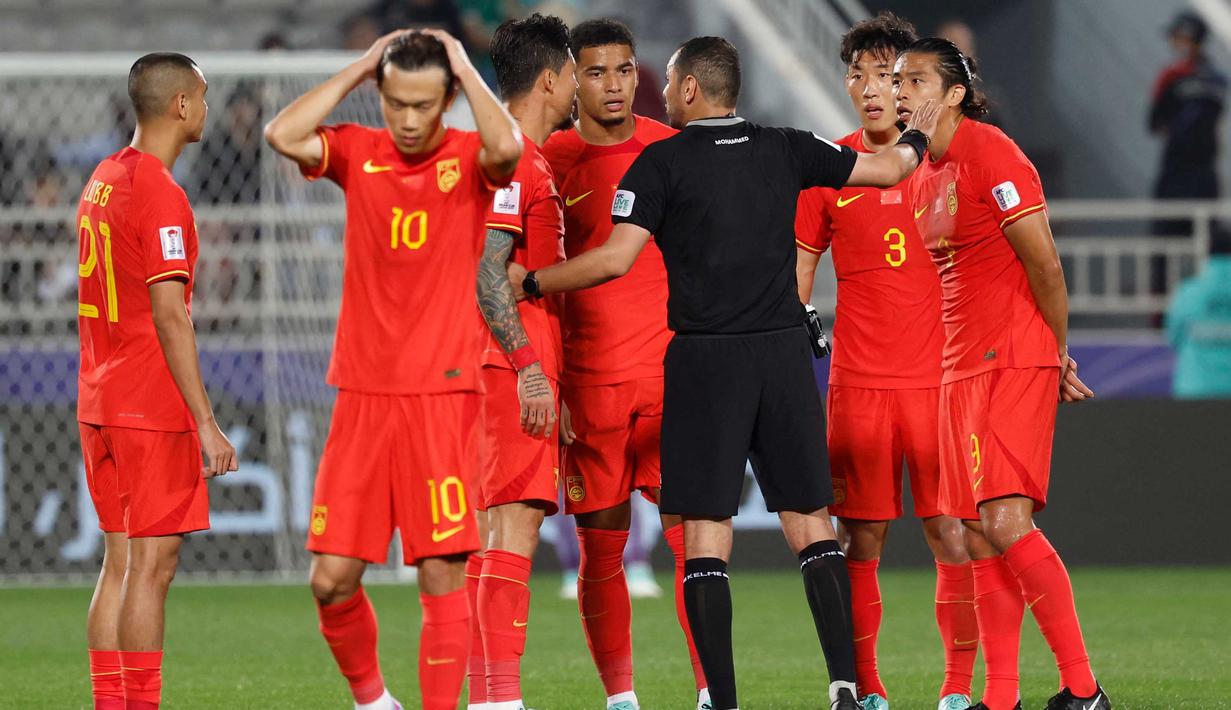 Wasit pertandingan, Mohammed Khaled al-Hoish berbicara dengan para pemain China saat pertandingan sepak bola Grup A Piala Asia AFC Qatar 2023 antara China dan Tajikistan di Stadion Abdullah bin Khalifa, Doha, 13 Januari 2024. (KARIM JAAFAR/AFP)