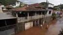 Warga membersihkan rumah usai banjir di Raposos, negara bagian Minas Gerais, Brasil, Selasa (11/1/2022). Tanah longsor akibat hujan deras telah menewaskan sedikitnya 12 orang dan pihak berwenang sedang memantau bendungan yang bisa jebol. (AP Photo/Eugenio Savio)