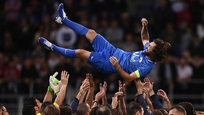 Mantan bintang timnas Italia, Andrea Pirlo diangkat oleh sejumlah pemain usai pertandingan perpisahan Andrea Pirlo di Stadion San Siro, Milan, Italia, (21/5). (AFP Photo / Marco Bertorello)
