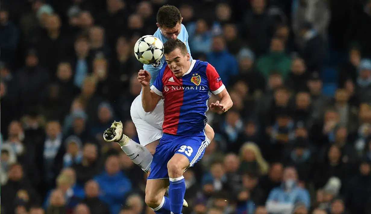 Gelandang FC Basel Kevin Bua berebut bola dengan bek Manchester City Aymeric Laporte saat pertandingan Liga Champions leg kedua  di Stadion Etihad, Manchester (7/3). Pada pertandingan ini Manchester City kalah 1-2 atas FC Basel. (AFP Photo / Oli Scarff)