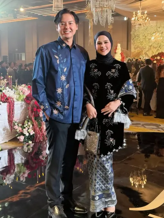 Cut Meyriska hadir bersama suaminya, Roger Danuarta yang kompak mengenakan baju nuansa navy. Cut Meyriska mengenakan long kebaya velvet dihiasi beads serta selandang dan bawahan kain batik. Roger pun tampil dengan atasan kemeja bermotif. [@cutratumeyriska]