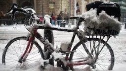 Sebuah sepeda tertutup salju di trotoar Broadway, New York, Selasa (14/3). Badai salju yang terjadi di sejumlah wilayah Amerika Serikat memaksa ribuan jadwal penerbangan dibatalkan dan sekolah-sekolah terpaksa ditutup sementara. (DON EMMERT/AFP)