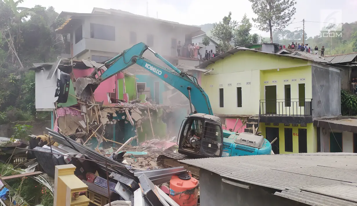 Pekerja mengoperasikan alat berat membongkar bangunan rumah di Kampung Naringgul, Kabupaten Bogor, Kamis (29/8/2019). Sebanyak 500 petugas gabungan dari Satpol PP, TNI dan Polri serta dua unit alat berat diterjunkan dalam pembongkaran puluhan bangunan semi permanen tersebut. (Liputan6.com/Alby Azka)