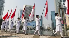 Sejumlah pasukan pengibar bendera (Paskibra) berbaris membawa bendera Merah Putih di Bundaran Hotel Indonesia (HI), Jakarta, Kamis (15/8/2024). (Liputan6.com/Herman Zakharia)