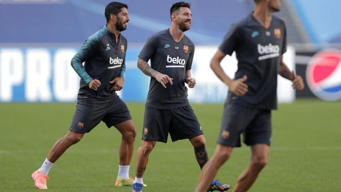 Penyerang Barcelona, Lionel Messi dan Luis Suarez melakukan pemanasan selama sesi latihan di stadion Da Luz, Lisbon, Portugal (13/8/2020). Barcelona akan bertanding melawan Bayern Munchen pada perempat final Liga Champions di Estadio da Luz. (Rafael Marchante/Pool via AP)
