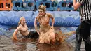 Dua orang wanita mengikuti World Gravy Wrestling Championships ke-10 di Rose 'n' Bowl Pub di Inggris (28/8). Pertandingan gulat ini cukup unik, karena digelar di sebuah kolam selam dua menit. (AFP Photo/Oli Scarff)