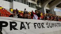 Sejumlah suporter Timnas Indonesia U-22 membentangkan spanduk PRAY FOR SUMETERA saat menonton SEA Games 2025 cabang olahraga sepak bola melawan Filipina U-22 di 700th Anniversary of Chiang Mai Stadium