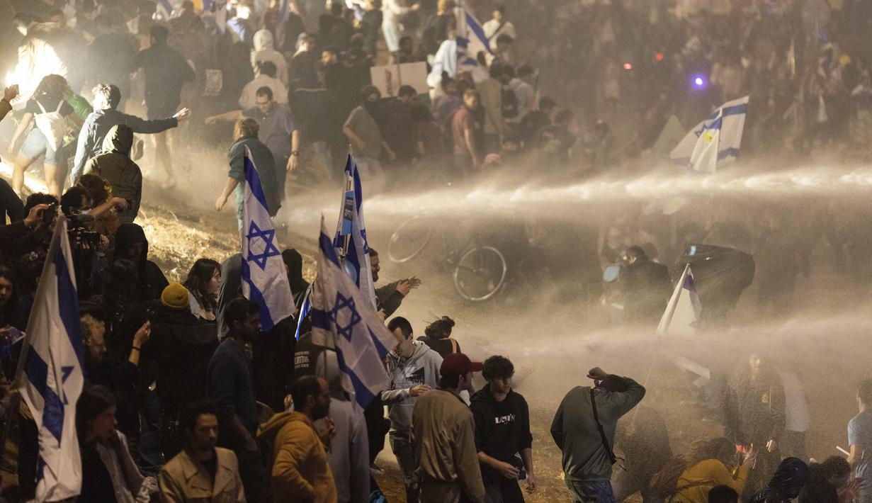 Polisi Israel menggunakan meriam air untuk membubarkan pengunjuk rasa yang memblokir jalan raya selama protes di Tel Aviv, Israel, Senin, 27 Maret 2023. (AP Photo/Oren Ziv)