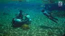 Pengunjung menaiki sepeda motor dalam kolam renang Umbul Ponggok, Desa Polanharjo, Klaten, Jawa Tengah, Minggu (30/9). Umbul Ponggok merupakan mata air yang dimanfaatkan sebagai pemandian dan snorkeling. (Liputan6.com/Gholib)