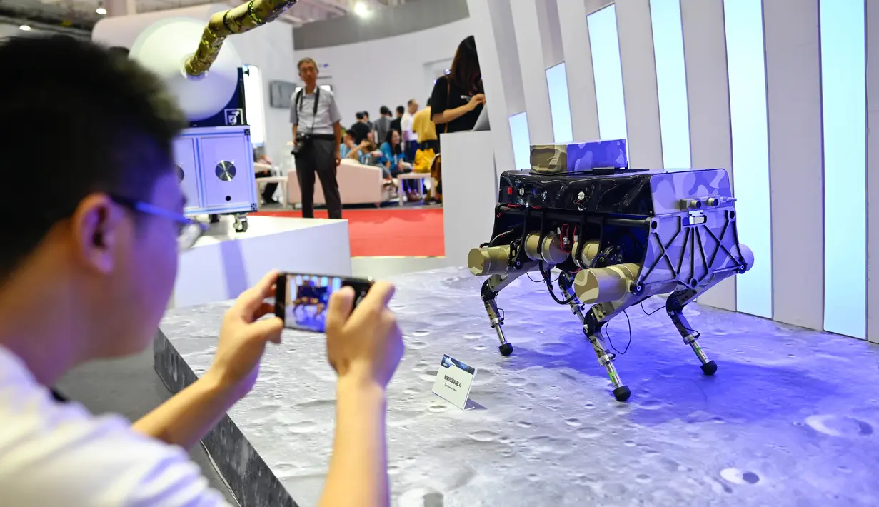 Pengunjung mengambil gambar robot berkaki empat dalam Konferensi Robot Dunia 2019 di Beijing, China, Selasa (20/8/2019). (WANG Zhao/AFP)