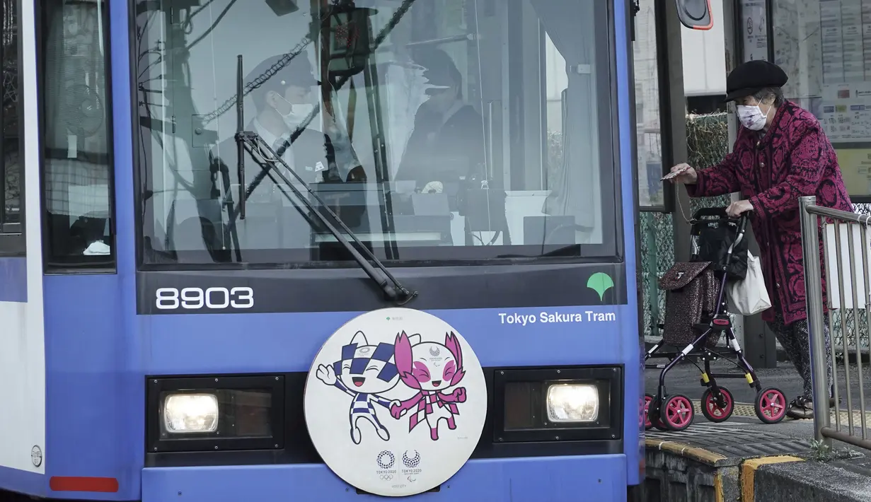 Seorang wanita yang mengenakan masker pelindung untuk membantu mengekang penyebaran virus corona di sebuah trem di Tokyo, Selasa (26/1/2021). Jepang mengonfirmasi lebih dari 1.000 kasus Virus Corona baru pada 26 Januari 2021. (AP Photo/Eugene Hoshiko)