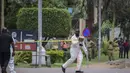 Seorang petugas forensik mengamankan lokasi ledakan di sebelah kantor polisi pusat di Kampala, Uganda (16/11/2021).  Serangan yang terjadi di dekat parlemen Uganda dan markas polisi terjadi hampir bersamaan dengan selisi kurang dari tiga menit. (AP Photo/Nicholas Bamulanzeki)