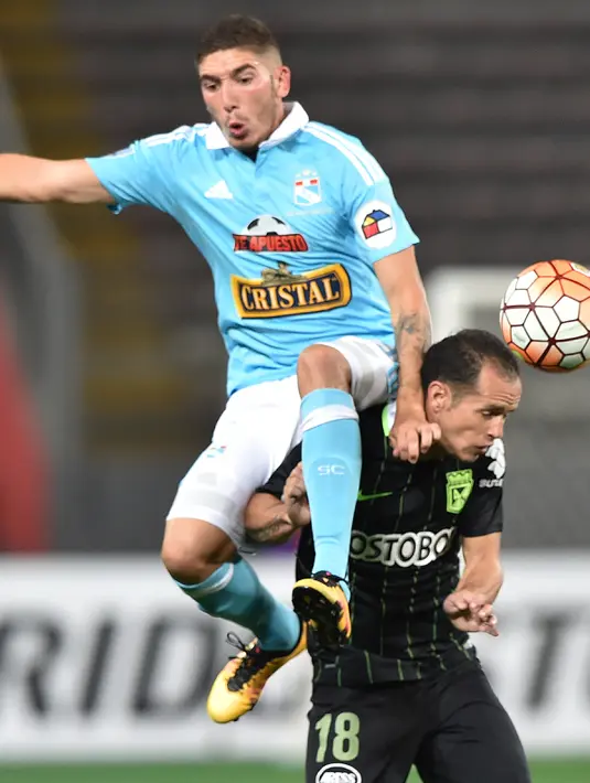 Pemain Atletico Nacional, Alejandro Guerra (kanan) saat beradu bola dengan pemain  Sporting Cristal di Stadion Nasional, Lima, April 2016. (CRIS BOURONCLE / AFP)
