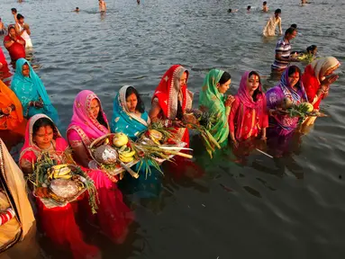 Sejumlah umat Hindu melakukan ritual menyembah dewa Matahari selama festival keagamaan Chhat Puja di Chandigarh, India (6/11). Ritual ini  merupakan bentuk terima kasih mereka kepada Dewa Matahari yang telah memberikan kehidupan. (Reuters/Ajay Verma)