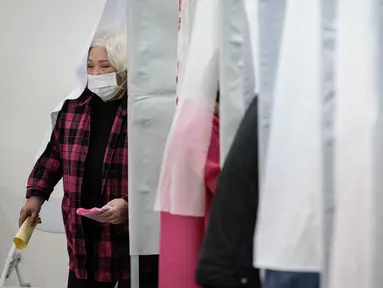 Seorang wanita meninggalkan bilik suara setelah menandai surat suara untuk memberikan suara dalam pemilihan presiden di sebuah tempat pemungutan suara di sebuah sekolah menengah atas di Tainan pada 13 Januari 2024. (Yasuyoshi CHIBA/AFP)