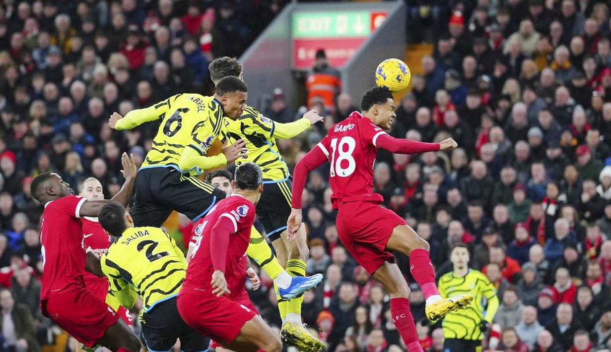 Pemain Arsenal, Gabriel Magalhaes, mencetak gol melalui tandukan kepala ke gawang Liverpool pada laga pekan ke-18 Premier League 2023/2024 di Stadion Anfield, Minggu (24/12/2023). Liverpool berada tepat di bawah Arsenal, dengan 39 poin dari jumlah laga yang sama. (AP Photo/Jon Super)