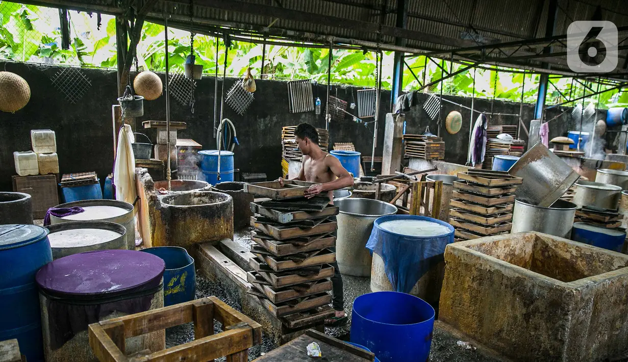 Pekerja merapikan tatakan di pabrik tahu tempe yang berhenti operasi di kawasan Duren Tiga, Jakarta, Sabtu (2/12/2021). Pusat Koperasi Produsen Tempe Tahu Indonesia atau Puskopti DKI Jakarta mengumumkan menghentikan sementara proses produksi tempe dan tahu. (Liputan6.com/Faizal Fanani)