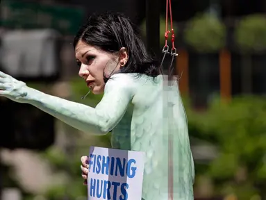 Seorang wanita bernama Victoria Lemeow menggelar aksi menolak penangkapan ikan di Seattle, AS, Senin (5/6). Aksi yang disponsori PETA  ini sebagai protes terhadap SeaWeb Seafood Summit yang diadakan di kawasan tersebut. (AP Photo / Elaine Thompson)