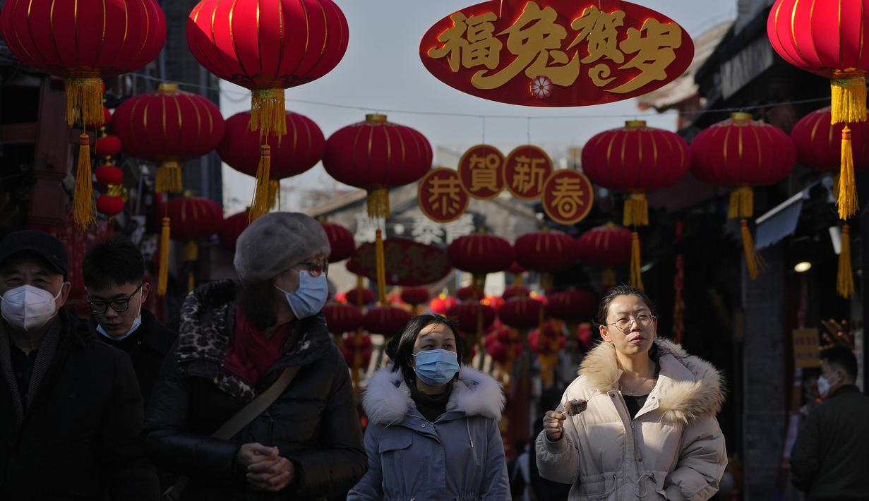 Pengunjung berkeliling di gang perbelanjaan dekat Danau Houhai yang memajang lentera dan dekorasi Tahun Baru Imlek di Beijing, Senin, 16 Januari 2023.  Organisasi Kesehatan Dunia (WHO) telah mengimbau China untuk terus merilis informasi tentang gelombang infeksi COVID-19 setelah pemerintah mengumumkan hampir 60.000 kematian sejak awal Desember menyusul keluhan selama berminggu-minggu karena gagal memberi tahu dunia apa yang terjadi. (AP Photo/Andy Wong)