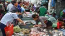 Seorang pelanggan memilih ikan dari penjual ikan di sebuah pasar di Phnom Penh (24/7/2020). Ibu kota Kamboja ini dipenuhi pasar baik besar maupun kecil. (AFP/Tang Chhin Sothy)