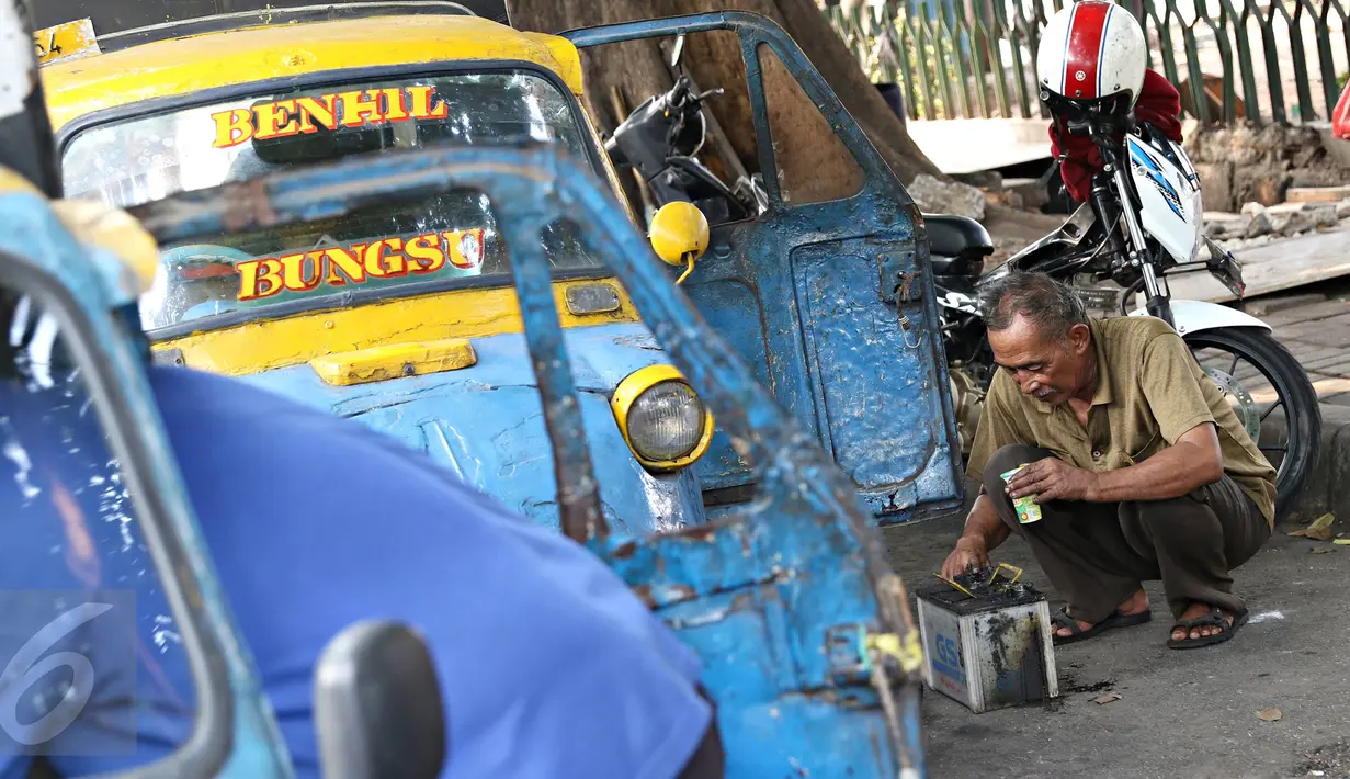 Sopir mengisi aki bemo di kawasan Bendungan Hilir, Jakarta, Kamis (22/10/2015). Maraknya perkembangan transportasi online di Ibu Kota membuat keberadaan angkutan bemo kian terpinggirkan akibat kalah bersaing. (Liputan6.com/Immanuel Antonius)