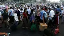 Pemudik melewati umat muslim yang baru saja melaksanakan Salat Idul Fitri di kawasan Senen, Minggu (25/6). Hari Raya Idul Fitri 1438 H disambut umat muslim dengan melaksanakan salat Ied di masjid-masjid dan tempat terbuka. (Liputan6.com/Johan Tallo)