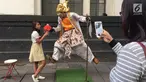 Pengunjung berpose dengan manusia patung di kawasan Museum Fatahilah, Kota Tua, Jakarta, Jumat (16/2). Libur Imlek 2018 dimanfaatkan warga untuk berwisata di sejumlah lokasi, Salah satu yang ramai dikunjungi yakni Kota Tua (Liputan6.com/Immanuel Antonius)