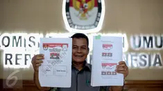 Kepala Subag Penyusunan Norma Desain dan Standar Kebutuhan Pemilu Biro Perencanaan Data KPU Sahono  menunjukan dua contoh surat suara untuk Pilkada Serentak 9 Desember 2015 di Gedung KPU, Jakarta, Rabu (11/11). (Liputan6.com/Faizal Fanani)