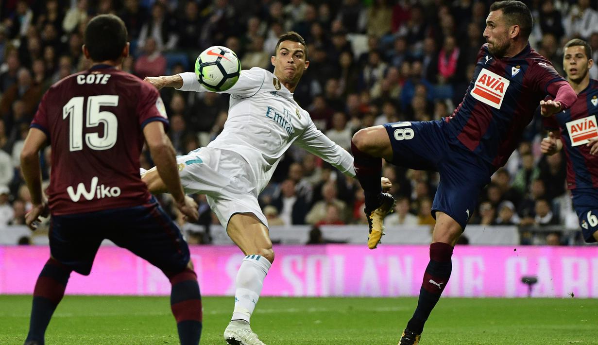 Cristiano Ronaldo (tengah) mencoba melakukan tembakan melewati adangan pemain Eibar, Jose Angel (kiri) dan Arbilla pada lanjutan La Liga Santander di Santiago Bernabeu stadium, Madrid, (22/10/2017). Madrid menang 3-0. (AFP/Pierre-Philippe Marcou)