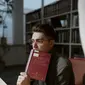 Pria berkacamata membaca kamus di perpustakaan (Liputan6.com/Pexels/tima-miroshnichenko)