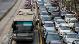 Dua pemotor menengok di belakang Transjakarta saat razia sterilisasi jalur Transjakarta di kawasan Mampang, Jakarta, Jumat (25/9/2015). Setiap harinya banyak pemotor yang nekat memasuki lajur busway yang semestinya steril. (Liputan6.com/Faizal Fanani)