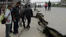 Jalan di Kathmandu terbelah dua akibat gempa bumi yang menghantam Nepal, Minggu (26/4/2015). Gempa berkekuatan 7,8 Skala Richter dikabarkan telah menelan korban sekitar 2000 jiwa. (AFP Photo/Prakash Mathema)
