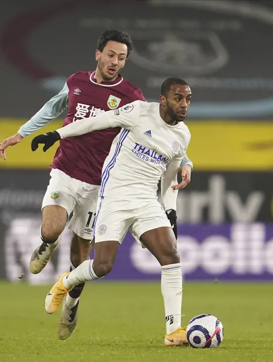 Penyerang Burnley, Dwight McNeil berusaha merebut bola dari bek Leicester City, Ricardo Pereira pada pertandingan Liga Inggris di stadion Turf Moor di Burnley, Inggris, Kamis (4/3/2021). Leicester City bermain imbang atas Burnley 1-1. (Jon Super/Pool via AP)