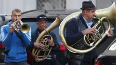 Aksi orkes tiup musisi Rumania untuk mendapat uang di jalanan Warsawa, Polandia pada 21 Oktober 2019. Orkes tiup yaitu sekelompok orang yang memperagakan musik dengan menggunakan instrumen musik tiup baik tiup logam maupun tiup kayu.  (AP Photo/Czarek Sokolowski)