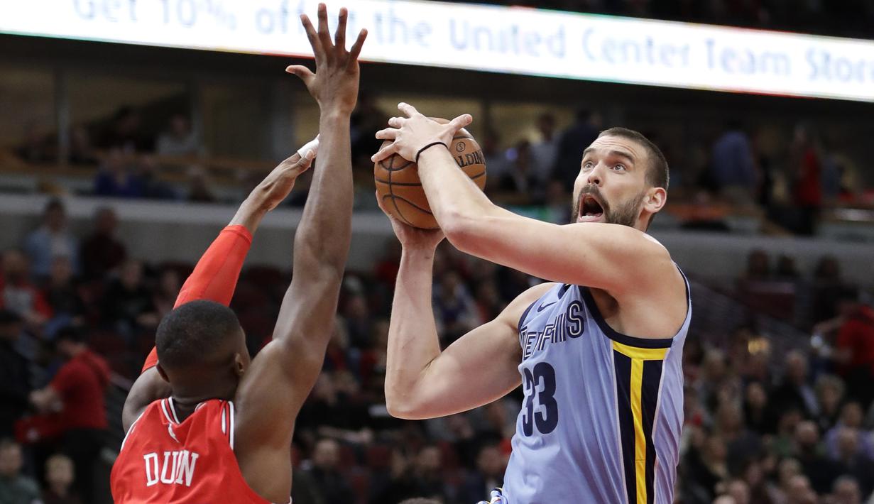 Gaya pemain Memphis Grizzlies, Marc Gasol (kanan) melewati adangan pemain Chicago Bulls, Kris Dunn pada laga NBA basketball game di United Center, Chicago, (7/3/2018). Chicago Bulls menang 119-110. (AP/Charles Rex Arbogast)