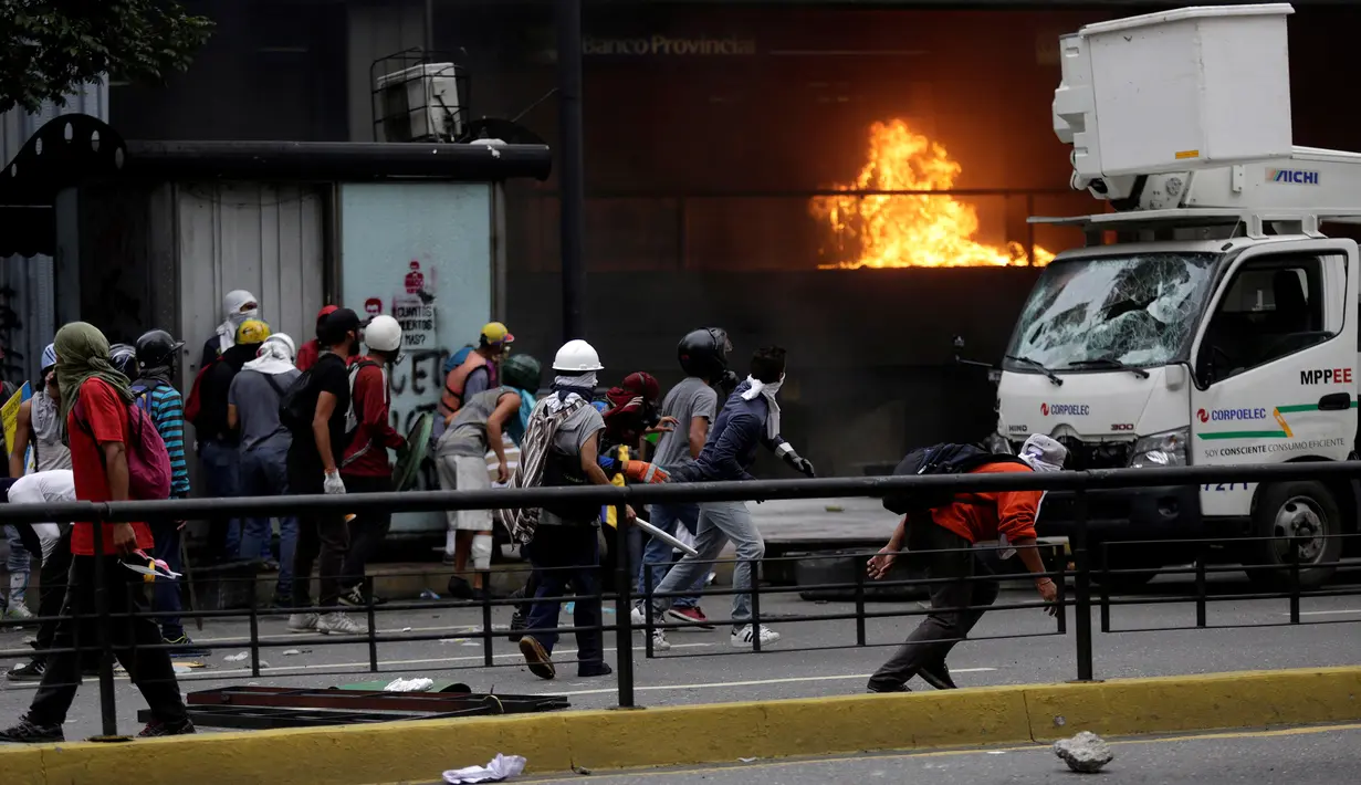 Sejumlah demonstran saat menyerang Gedung Pengadilan Tinggi Venezuela selama kerusuhan menuntut Presiden Nicolas Maduro di Caracas (7/6). (Reuters/Marco Bello)