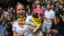 Courtney Terrey berpose dengan anjingnya setelah memenangkan perlombaan di "HK Doggie Dash 2018" di Hong Kong (15/4). Perlombaan ini diadakan untuk mengumpulkan uang bagi anjing yang telah diterlantarkan dan diselamatkan. (AFP Photo/Isaac Lawrence)