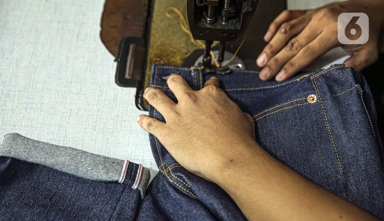 Penjahit menjahit bahan di Nyoel Jeans co, Jakarta, Jumat (22/10/2021). Harga kapas saat ini mencapai USD 1,16/pon atau sekitar Rp 16.530/pon (asumsi kurs Rp 14.250/USD). (Liputan6.com/Faizal Fanani)