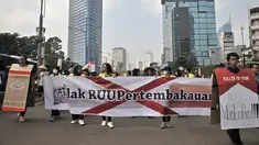 Mahasiswa Universitas Indonesia (UI) membawa spanduk saat menggelar kampanye Bahaya Merokok di car free day (CFD), Jakarta, Minggu (6/5). Dalam aksinya, mahasiswa menolak RUU Pertembakauan. (Merdeka.com/Iqbal Nugroho)