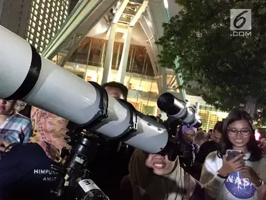 Pengunjung menggunakan teropong untuk melihat berlangsungnya fenomena gerhana bulan total di Taman Ismail Marzuki, Jakarta, Rabu (31/1). Kegiatan nonton bareng Super Blue Blood Moon ini digelar di Planetarium Jakarta. (Liputan6.com/Immanuel Antonius)