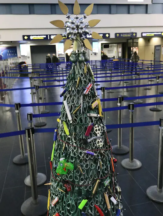 Pohon Natal yang dirakit dari barang-barang sitaan di Bandara Vilnius, Lithuania pada 12 Desember 2019. Bagian tubuh pohon Natal dibuat dengan menggunakan gunting yang dicat warna hijau agar terlihat seperti daun. . (Photo by Petras Malukas / AFP)